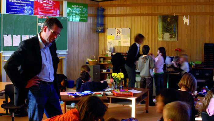 一名教师在采用飞利浦学校照明的 In der Alten Forst 内帮助学生