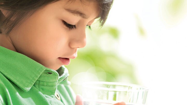 一个小男孩凝视着一杯清水