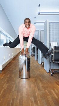 一个男人正在采用飞利浦动态照明的办公室走廊上跳跃