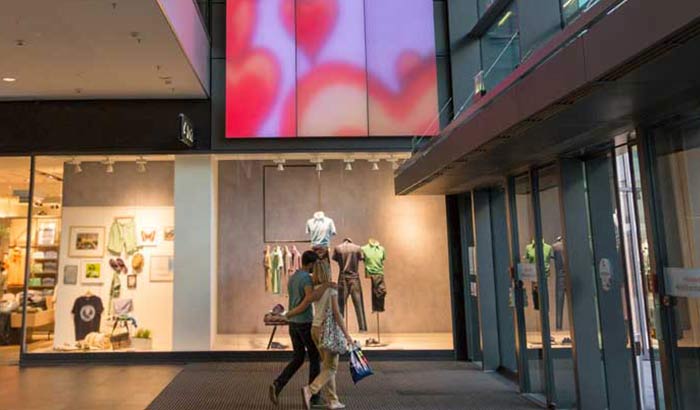 一对爱侣凝视着 Centrum Galerie 购物中心内不断变幻的 Luminous Textile 显示屏