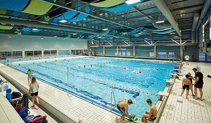 游泳爱好者在灯火通明的 Veenendaal 室内游泳池内轻松畅游