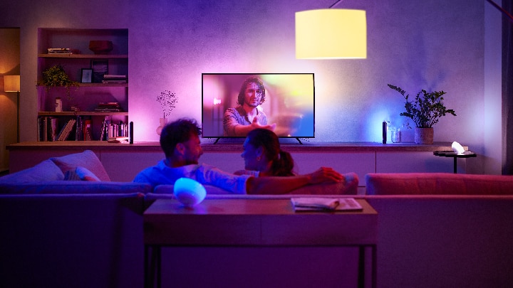Person controlling colored lights in the living room