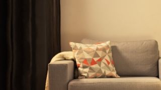 “舒适的客厅配有现代 LED 桌灯，照亮灰色的双人沙发，营造出温馨的居家放松氛围。”