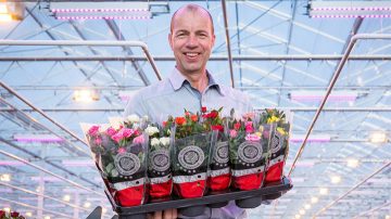 照片中为 Leo van der Harg 手捧五颜六色的鲜花。